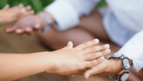 Hands reaching out in connection during trauma-informed relationship coaching training at Soul Awakening Academy