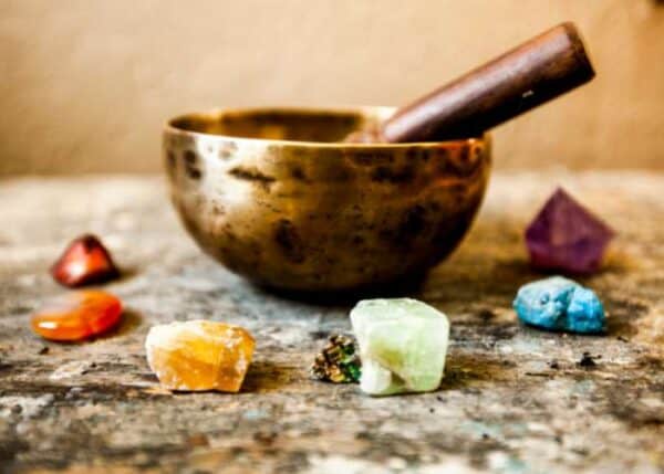 Chakra affirmation healing course - colourful chakra crystals with singing bowl used in energy aware practices and meditation