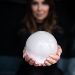 Anne-Marie, owner of Soul Awakening Academy professional image holding a crystal sphere, representing chakra healing, spiritual coaching, and energy work.