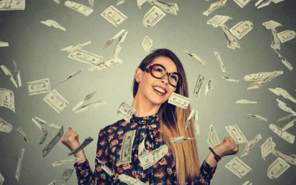 Woman celebrating financial success, symbolising business astrology money potential – Soul Awakening Academy.